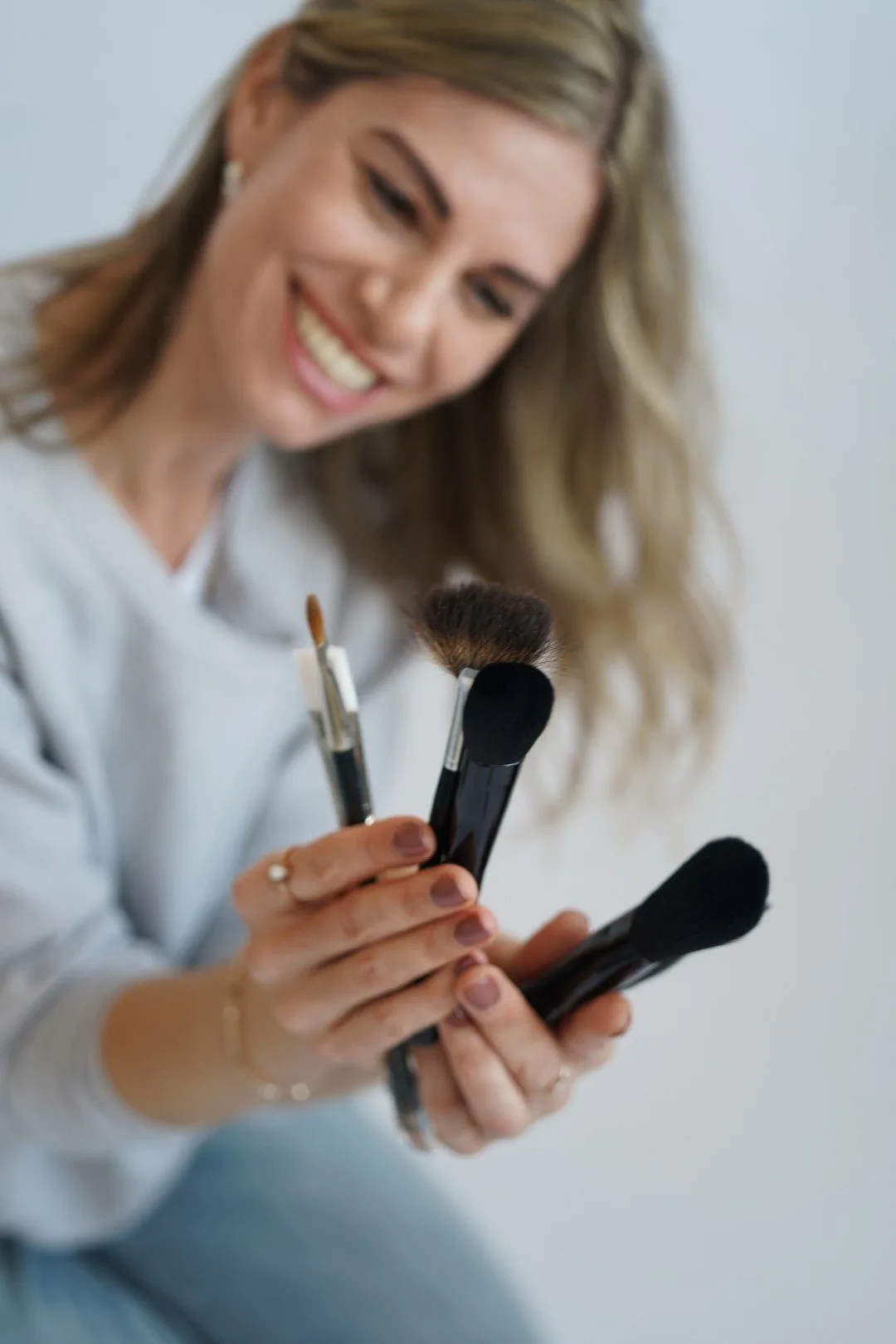 Kosmetikerin hält Make-up-Pinsel in der Hand